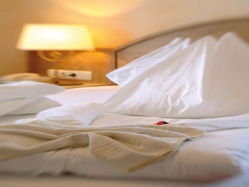 an unmade bed with white sheets and pillows at Hotel Salzburger Hof in Dienten am Hochkönig