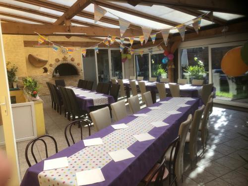 a room with long tables and chairs with purple table cloth at Willa chez willi in Niederschaeffolsheim