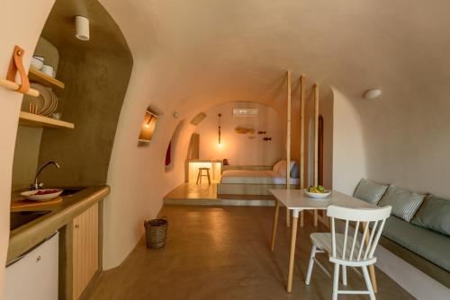 a kitchen and living room with a table and chairs at Sublime Villa & Caves in Akrotiri