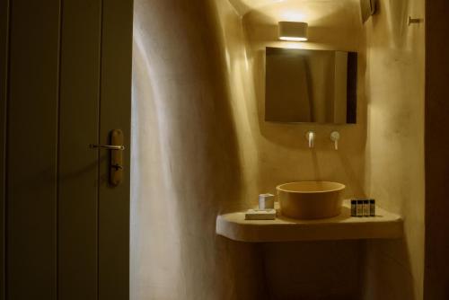 a bathroom with a sink and a mirror at Sublime Villa & Caves in Akrotiri