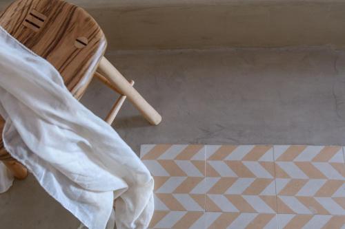 a wooden chair sitting next to a geometric rug at Sublime Villa & Caves in Akrotiri