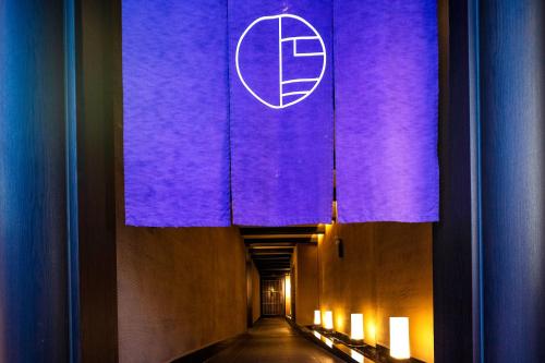 a tunnel with a purple wall with a logo on it at Hotel Kuu Kyoto in Kyoto