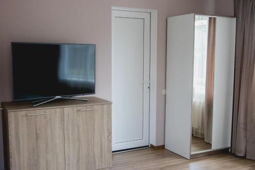 uma televisão de ecrã plano em cima de um armário de madeira em Apartments in Joniškis em Joniskis