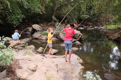 a man and a child standing on a rock in a river at LakeSide Cabana Tissamaharama in Tissamaharama