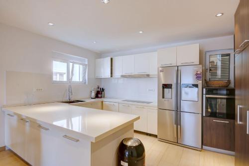 a kitchen with white cabinets and a stainless steel refrigerator at Fashion Beach Apartments in Risan