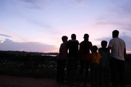 a group of people standing in front of the sunset at LakeSide Cabana Tissamaharama in Tissamaharama