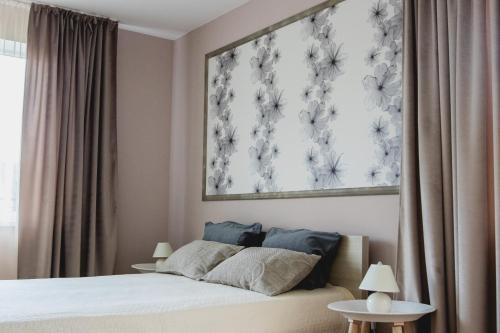 um quarto com uma cama com um quadro na parede em Apartments in Joniškis em Joniskis