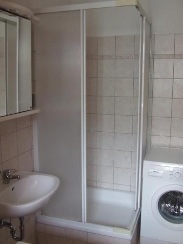 a bathroom with a washing machine and a sink at Central Pécs Free Parking in Pécs