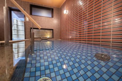 a large swimming pool with blue tiles in a room at Hotel Kuu Kyoto in Kyoto