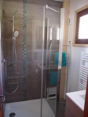 une douche avec une porte vitrée dans une salle de bain dans l'établissement Le Pytoux, à Saint-Gervais-les-Bains