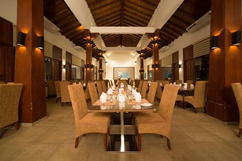 un comedor con una mesa larga y sillas en The Thinnai - All-Suites Boutique Hotel, en Jaffna