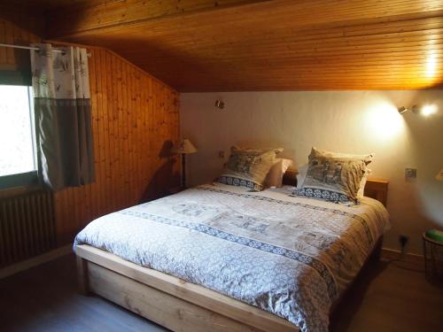 une chambre avec un grand lit avec un plafond en bois dans l'établissement Le Pytoux, à Saint-Gervais-les-Bains