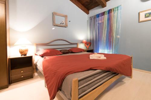 a bedroom with a large bed with a red bedspread at Haus Stepcich in Plomin