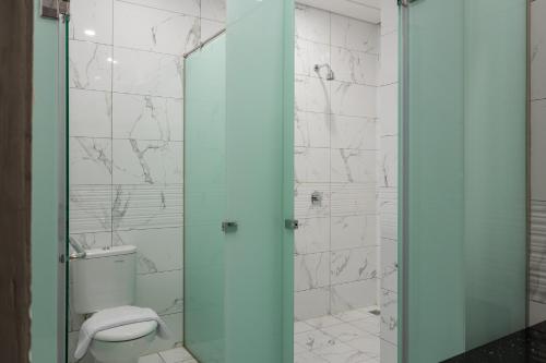 a bathroom with a glass shower with a toilet at RedDoorz Plus near Senayan City in Jakarta