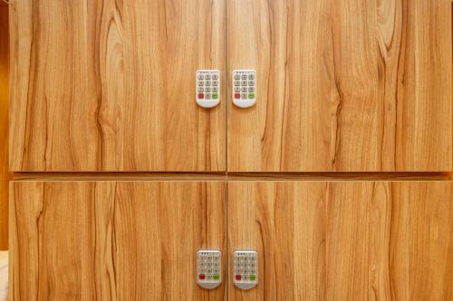 a wooden cabinet with two remote controls on it at RedDoorz Plus near Senayan City in Jakarta