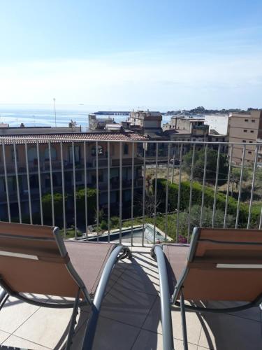 two chairs sitting on top of a balcony at villa aurora in Giardini Naxos