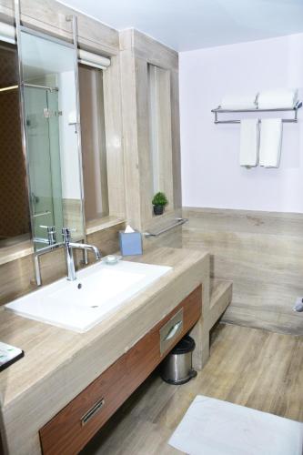 a bathroom with a sink and a mirror at Quality Inn Gurgaon in Gurgaon