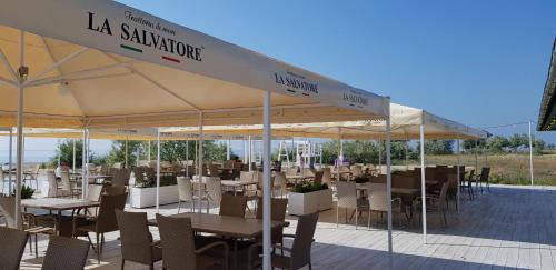 a restaurant with tables and chairs under a tent at Грибовка Апартаменты 134 - 137 Black Sea Bugaz in Gribovka