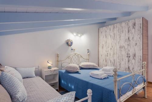 una camera con due letti e un soffitto blu di House of Arts a Kokkari