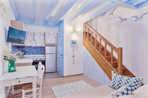 eine Küche und ein Wohnzimmer mit einer Treppe und einem Tisch in der Unterkunft House of Arts in Kokkari