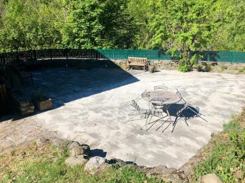 a stone patio with a table and a bench at Mas Graffouil in Prats-de-Mollo-la-Preste