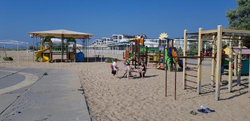 un parque infantil en la playa con gente jugando en él en Грибовка Апартаменты 137 - Black Sea Bugaz en Gribovka