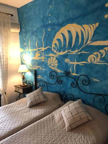 a bedroom with a bed and a mural of a lobster at Thalassa Hotel in Ammouliani