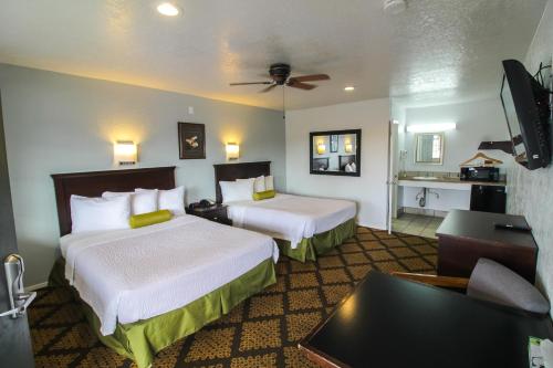 a hotel room with two beds and a couch at Stage Stop Inn Williams in Williams