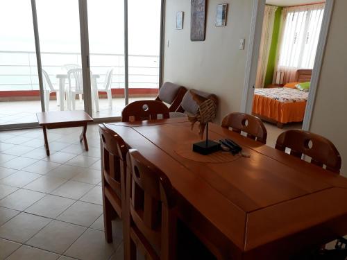a living room with a wooden table and chairs at Arco Iris Atacames in Atacames