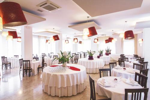 a dining room with white tables and chairs at Hotel Panama Majestic in Rimini