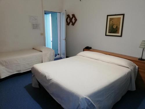 a hotel room with two beds and a window at Hotel Caprice in Marina di Massa