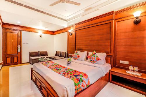 um quarto de hotel com uma cama e uma cadeira em Hotel Summit em Ahmedabad