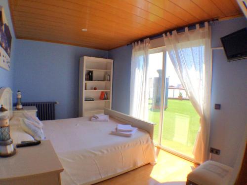 ein Schlafzimmer mit einem Bett und einem großen Fenster in der Unterkunft Calella Skyline in Calella