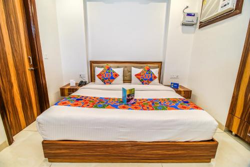 a bedroom with a large bed with colorful pillows at FabHotel Kiara- 400 meters from Medanta hospital in Gurgaon