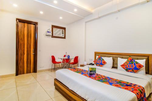a bedroom with a large bed and a table in it at FabHotel Kiara- 400 meters from Medanta hospital in Gurgaon