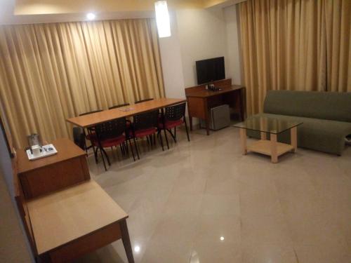a living room with a couch and a table at Goa Woodlands Hotel in Madgaon