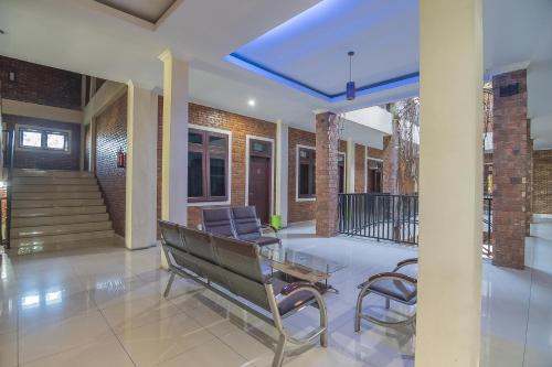a lobby with a bench and a table and chairs at RedDoorz Plus near Cambridge City Square 2 Medan in Medan