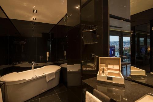 a bathroom with a bath tub and a sink at Key Hotel in Izmir