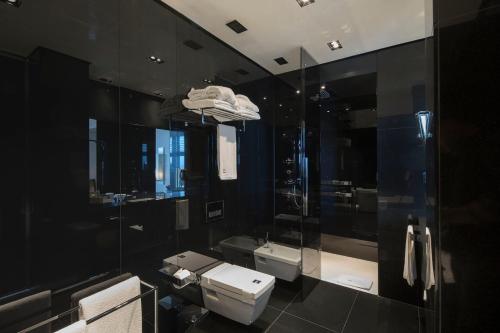 a black bathroom with two toilets and a shower at Key Hotel in Izmir