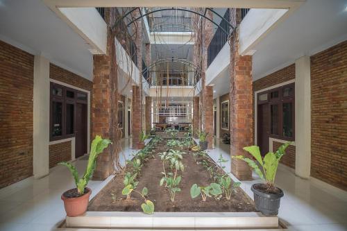 a room with plants in the middle of a building at RedDoorz Plus near Cambridge City Square 2 Medan in Medan