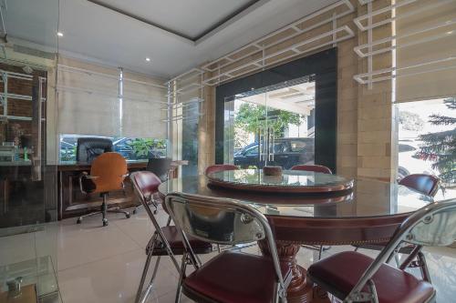 a dining room with a table and chairs and a fireplace at RedDoorz Plus near Cambridge City Square 2 Medan in Medan