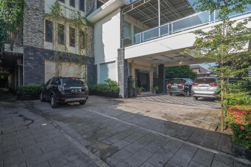 a parking lot with cars parked in front of a building at RedDoorz Plus near Cambridge City Square 2 Medan in Medan