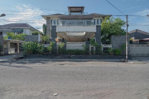 a house on the side of a street at RedDoorz Plus near Cambridge City Square 2 Medan in Medan
