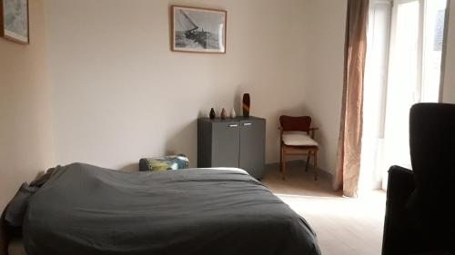 a bedroom with a bed and a table and a chair at Tiguil in Le Guilvinec