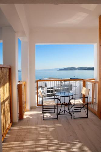 a balcony with a table and chairs and a view of the ocean at Megali Ammos House in Megali Ammos