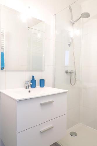 une salle de bain blanche avec un lavabo et une douche dans l'établissement La Provence, à Nice