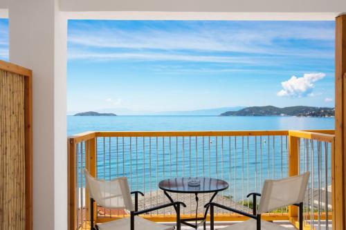 a balcony with a table and chairs and a view of the ocean at Megali Ammos House in Megali Ammos
