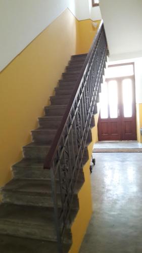 a staircase with a metal railing next to a door at La Casa di Davide - David Home in Cave del Predil