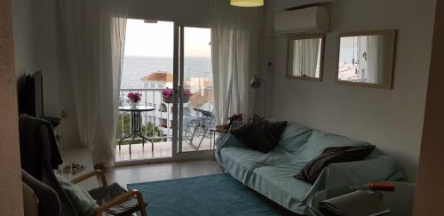 - un salon avec un canapé et une vue sur l'océan dans l'établissement Apartment Edificio Sur 19, à Nerja