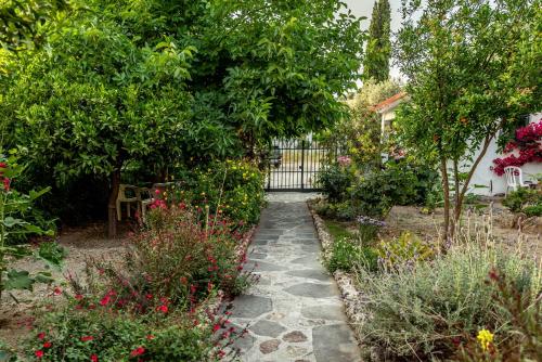 a garden path with flowers and a fence at Hotel Ikaros in Archangelos